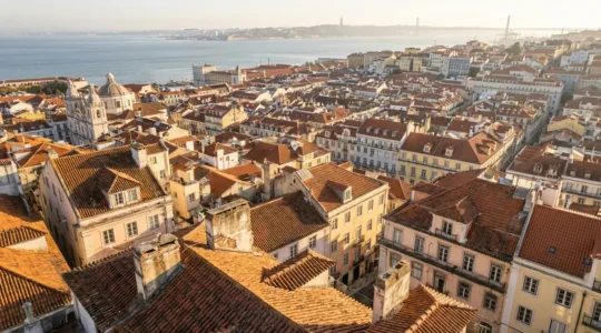 Vue aérienne ensoleillée sur les toits colorés de Lisbonne avec le Tage en arrière-plan